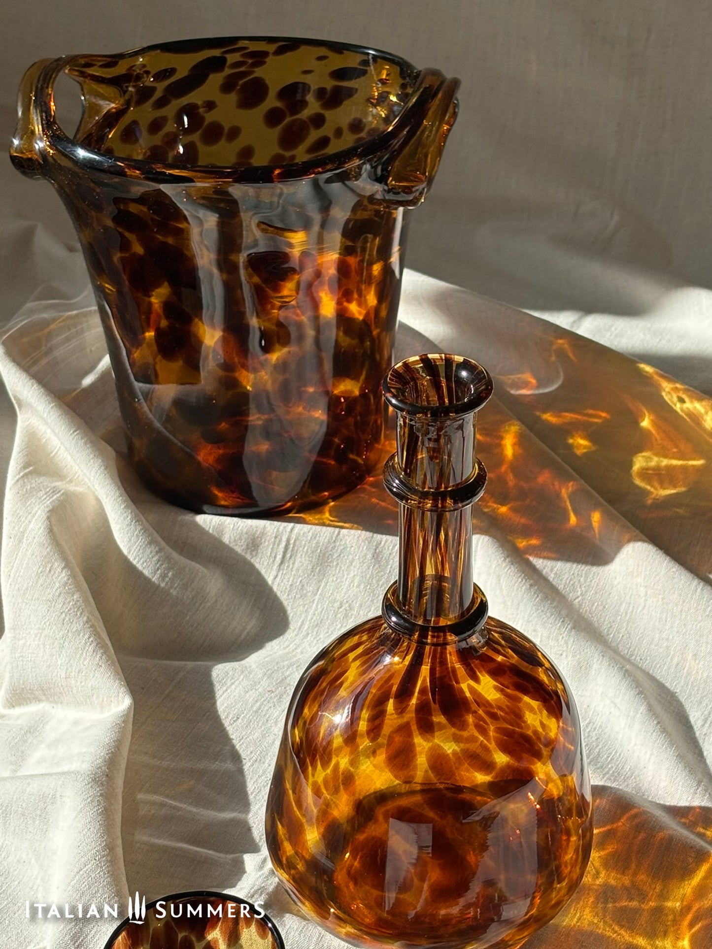 Tortoiseshell patterned glass items on a light fabric background