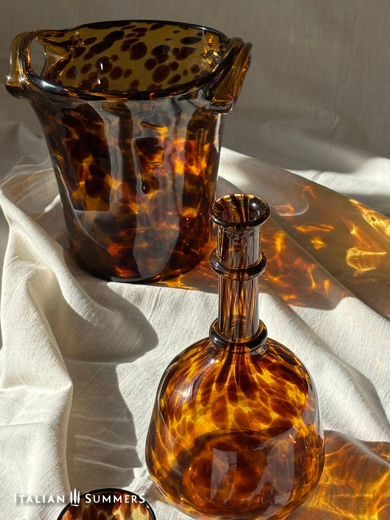 Tortoiseshell patterned glass items on a light fabric background