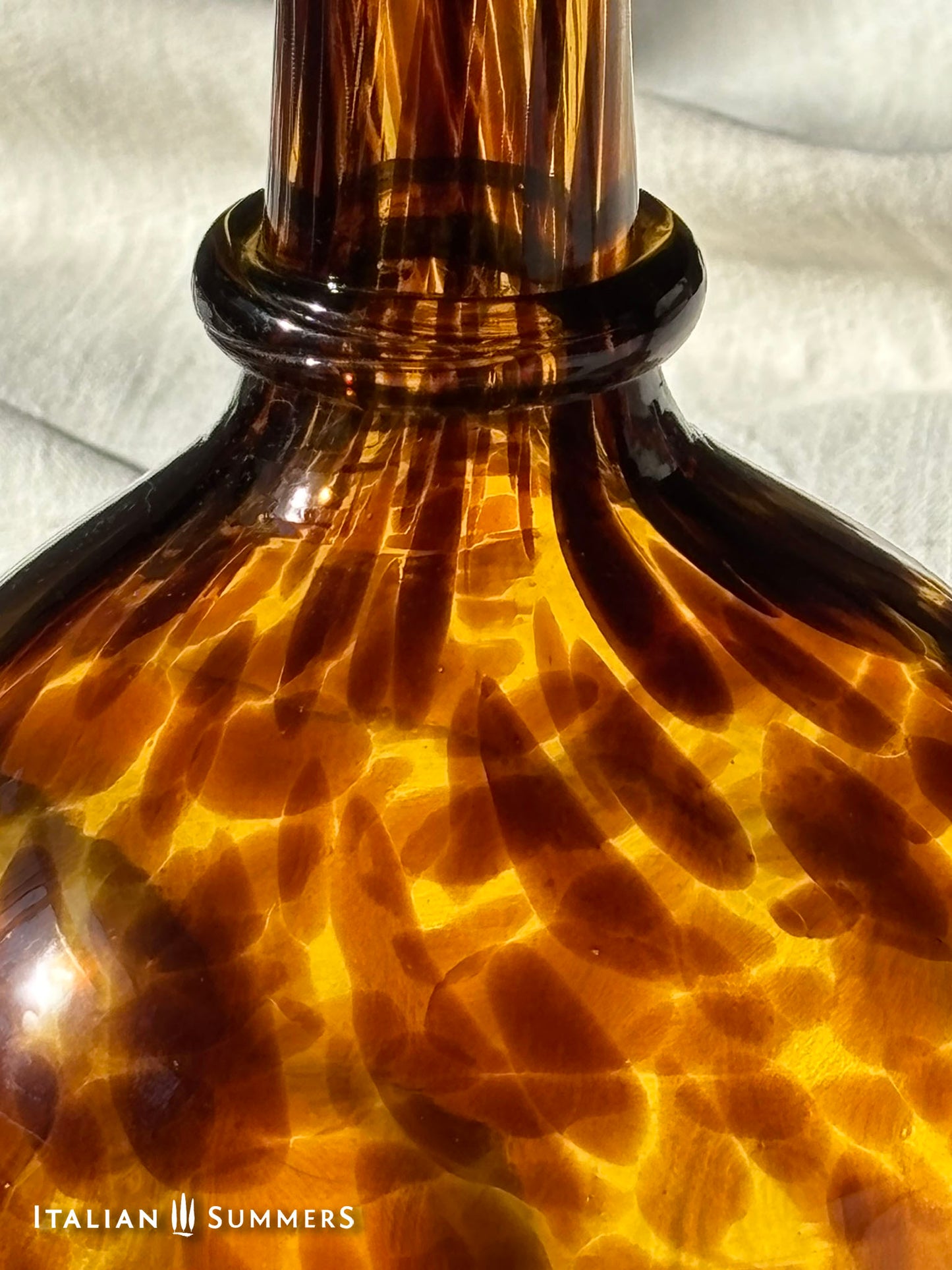 Close-up of a tortoiseshell-patterned bottle with 'Italian Summers' branding.